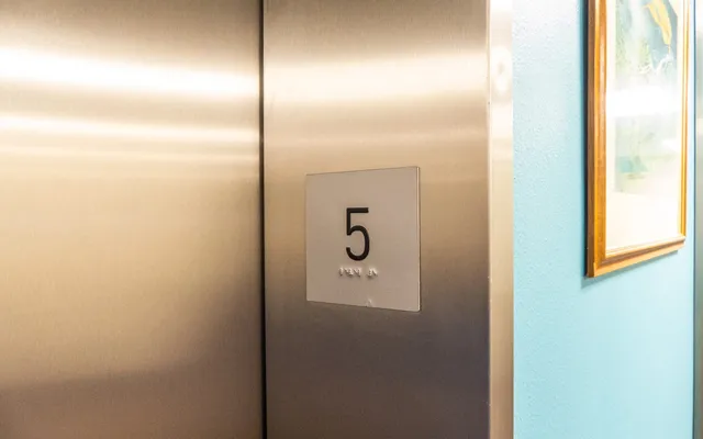 A lift call panel with a large floor number and braille beneath it