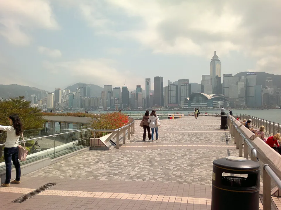 The Tsim Sha Tsui promenade leading towards the harbour and skyline on a clear day