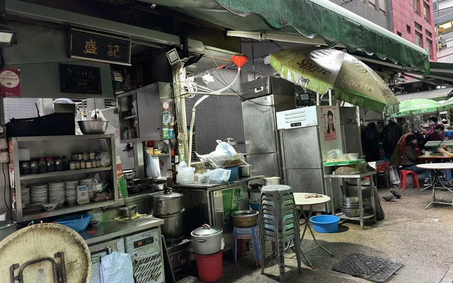 A dai pai dong kitchen on Stanley Street with steel counters, stools and green awnings