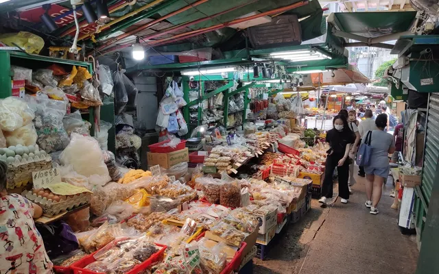 Graham Street market stalls under green canopies, crates of dried goods in the foreground