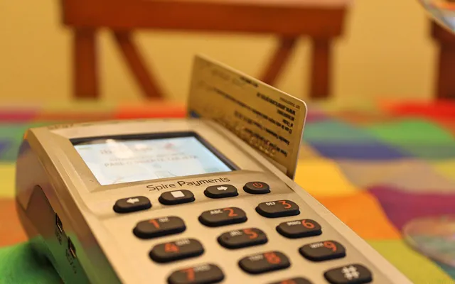 A bank card inserted into a handheld payment terminal