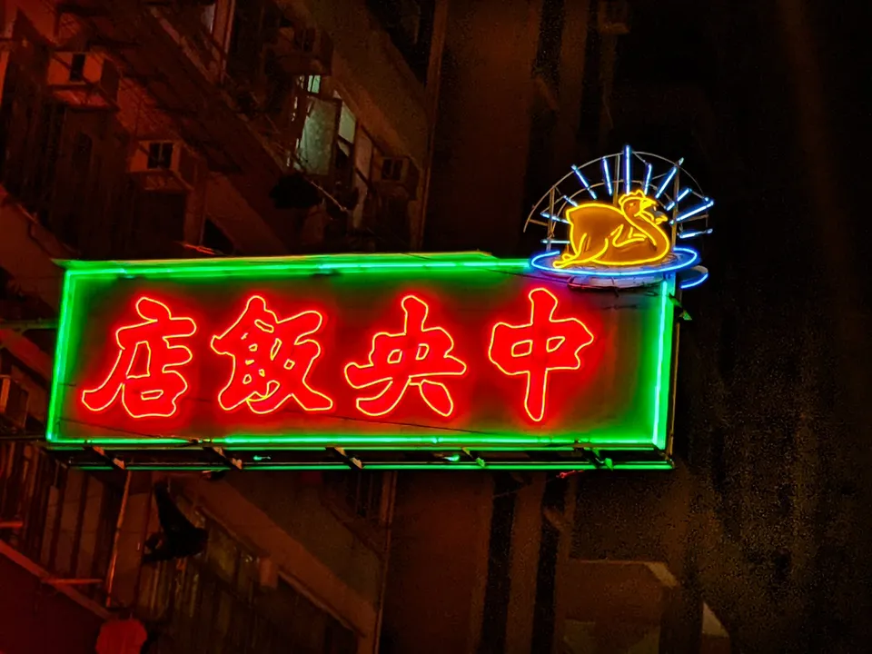 A red and green neon sign reading Central Restaurant against a dark facade