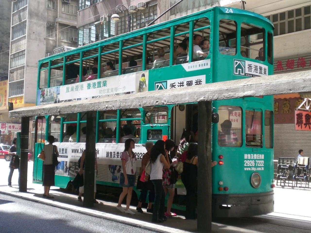 Midday: passengers board at a Sai Ying Pun stop, one door in, one door out.