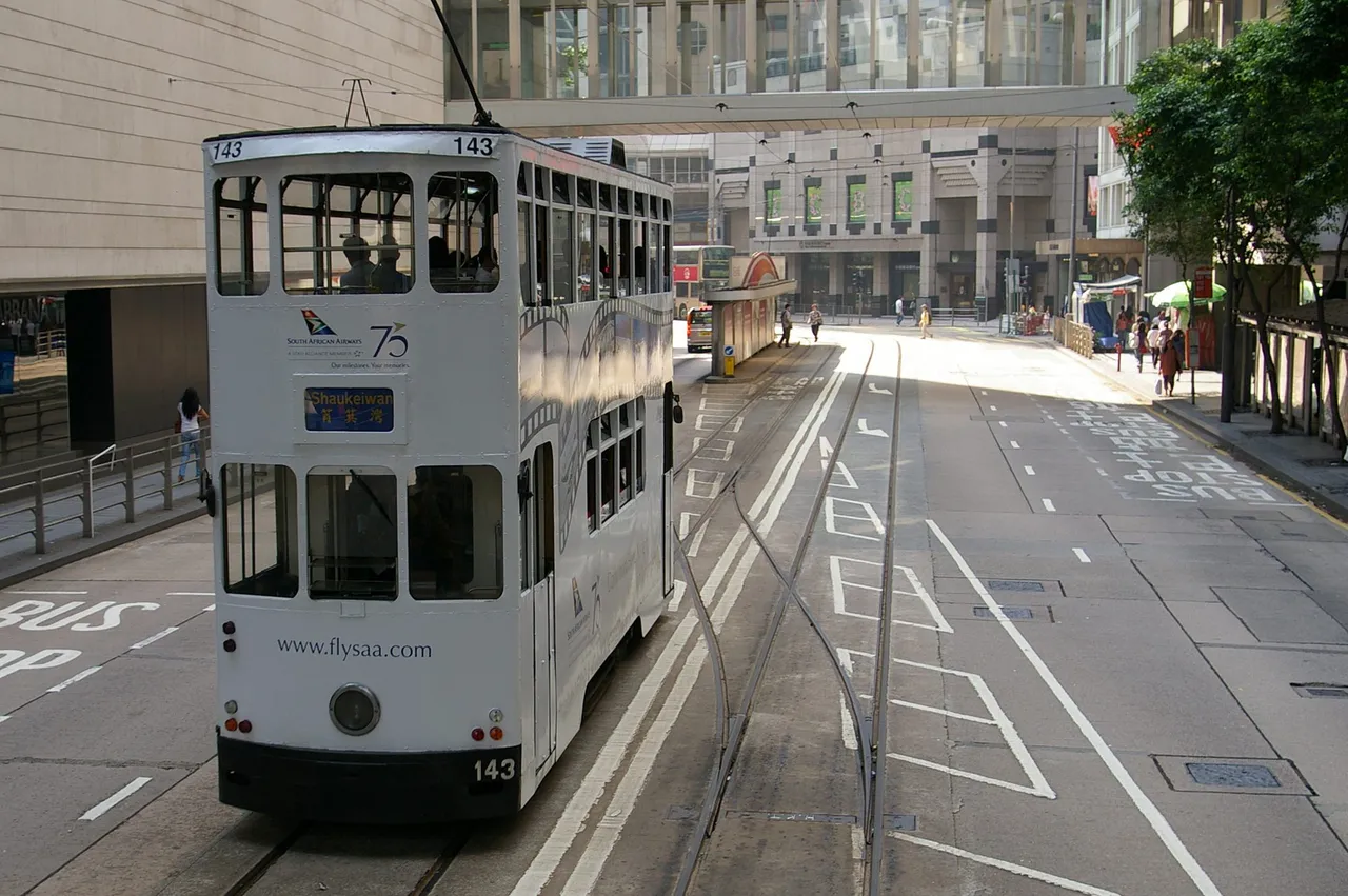 Morning: an early tram with its route number lit, on an almost empty street.