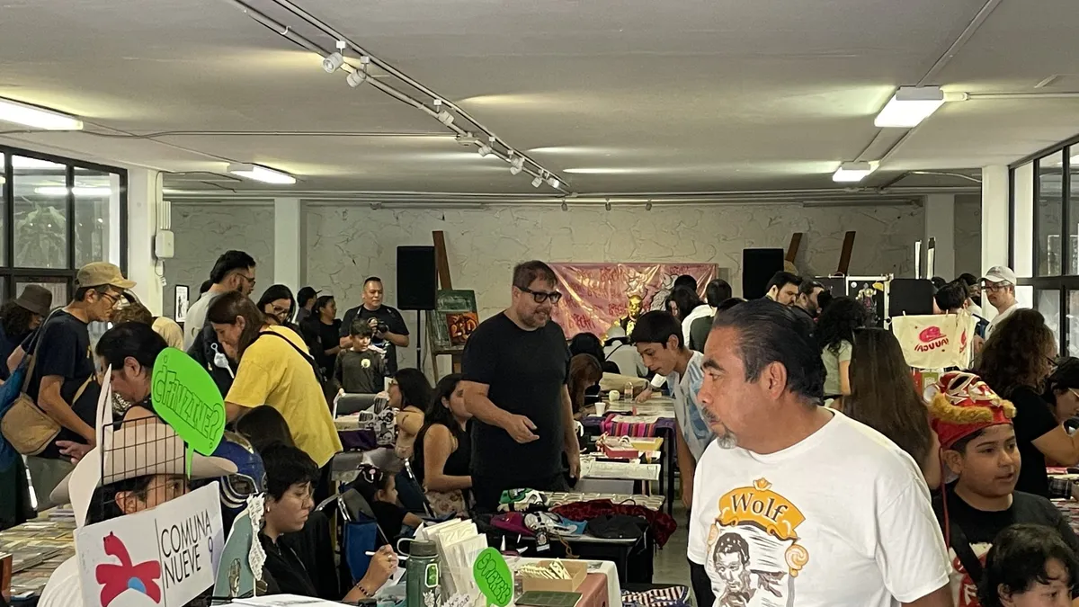 Visitors browsing tables at a busy zine fair