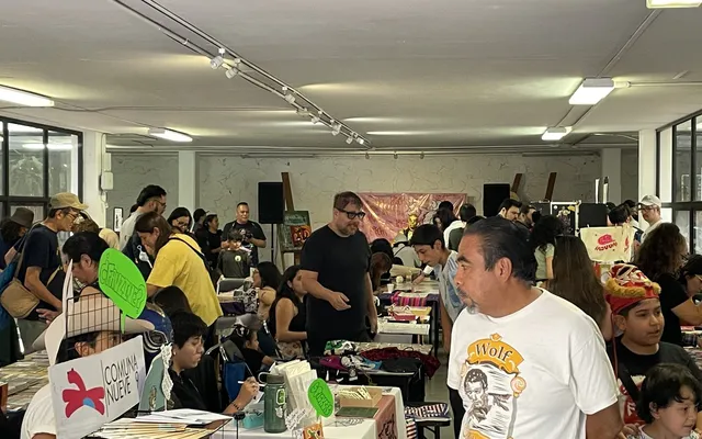Visitors browsing tables at a busy zine fair