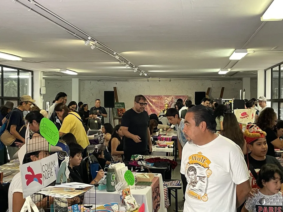 Visitors browsing tables at a busy zine fair